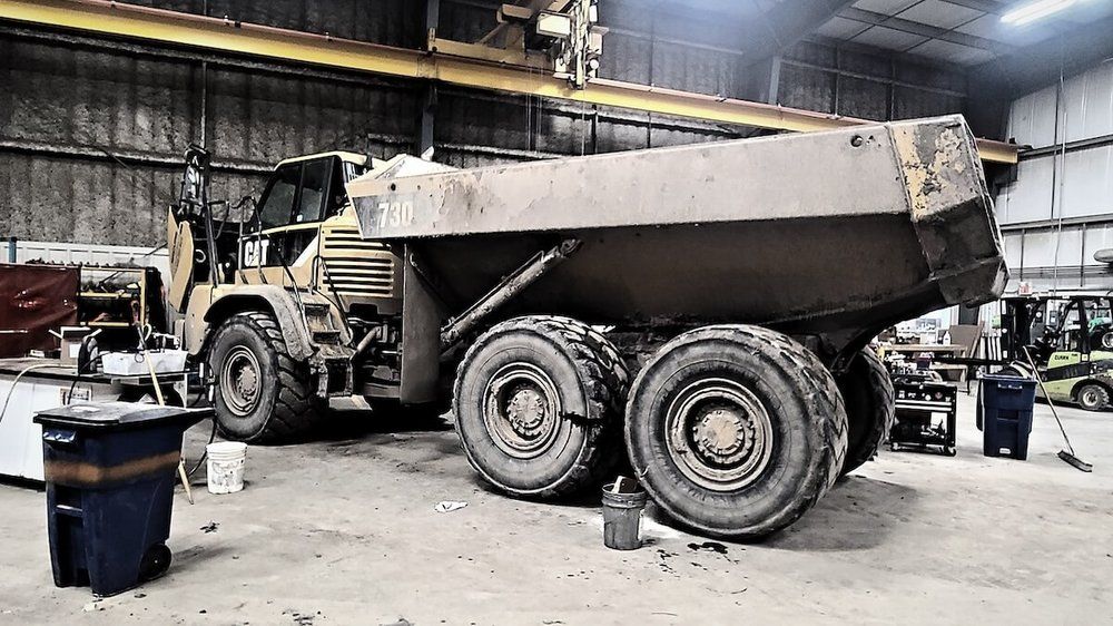 CAT articulated rock truck inside the Mach 6 shop bay under the overhead crane